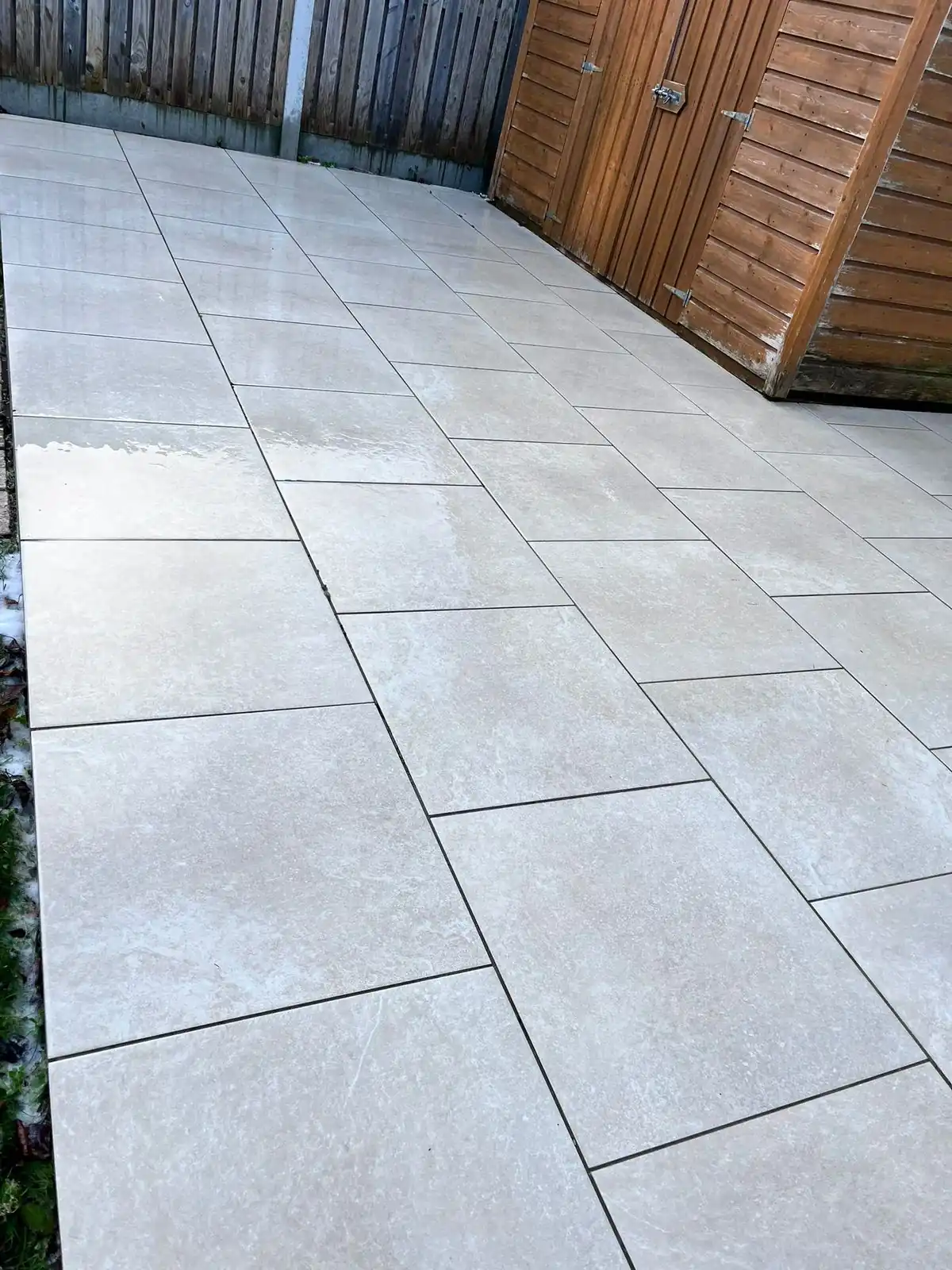 Concrete patio slabs cleaned to lift dirt and organic surface build-up