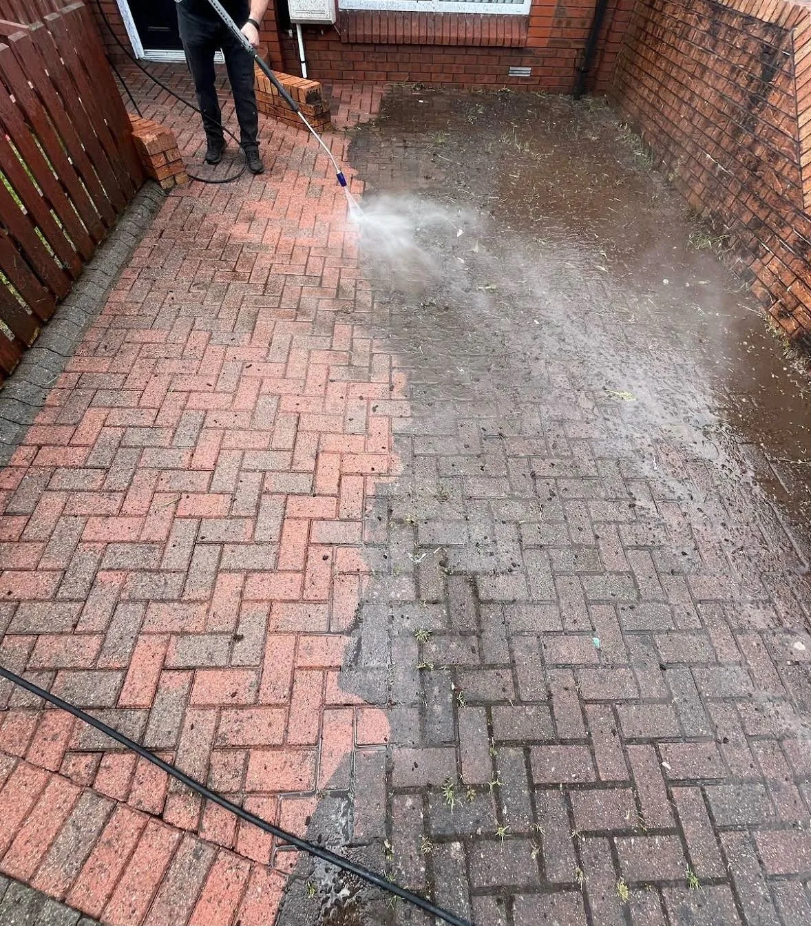 Power washing a block paving driveway in Dublin — half cleaned showing before and after