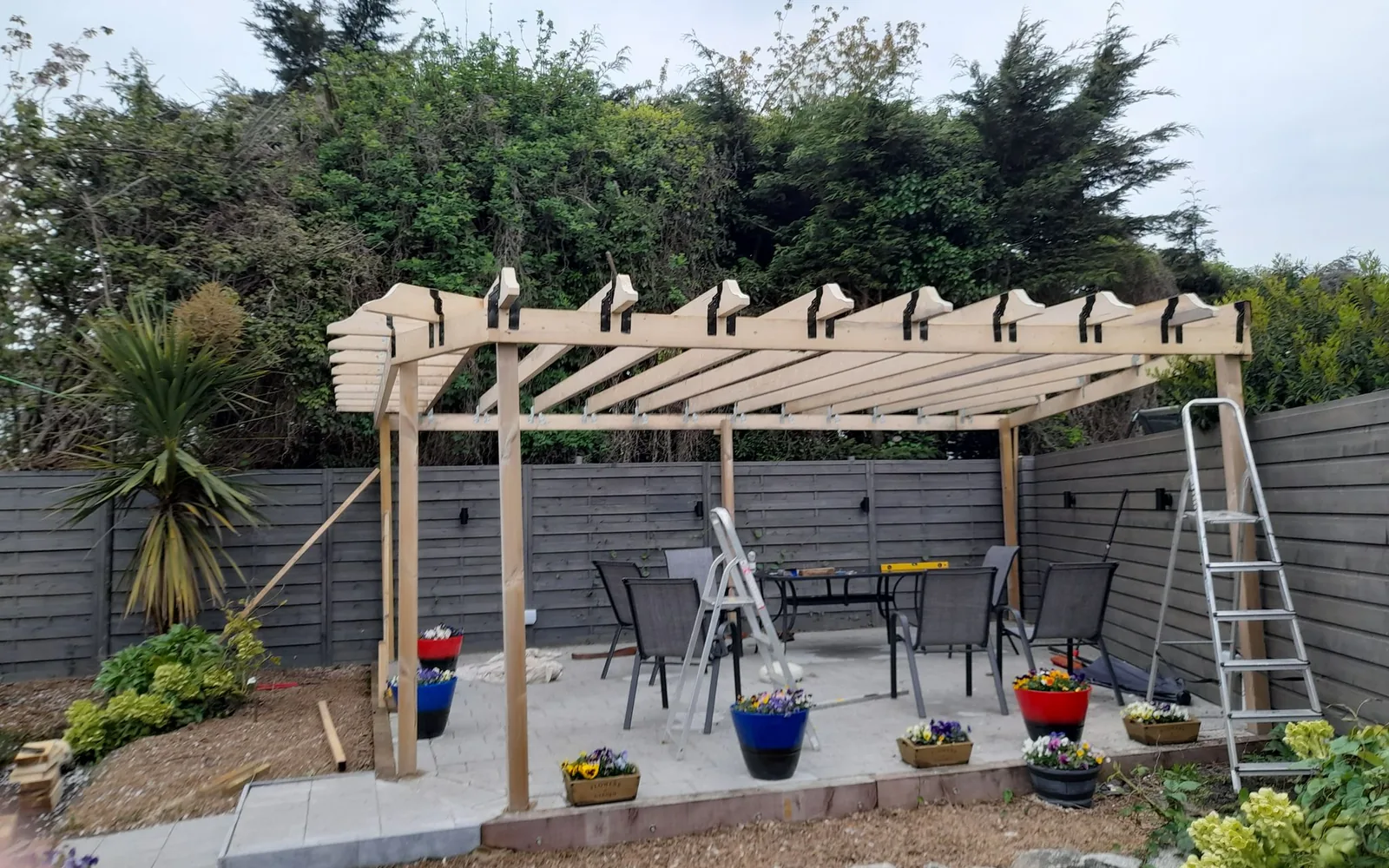 Dublin garden during build: timber pergola frame going up over the patio