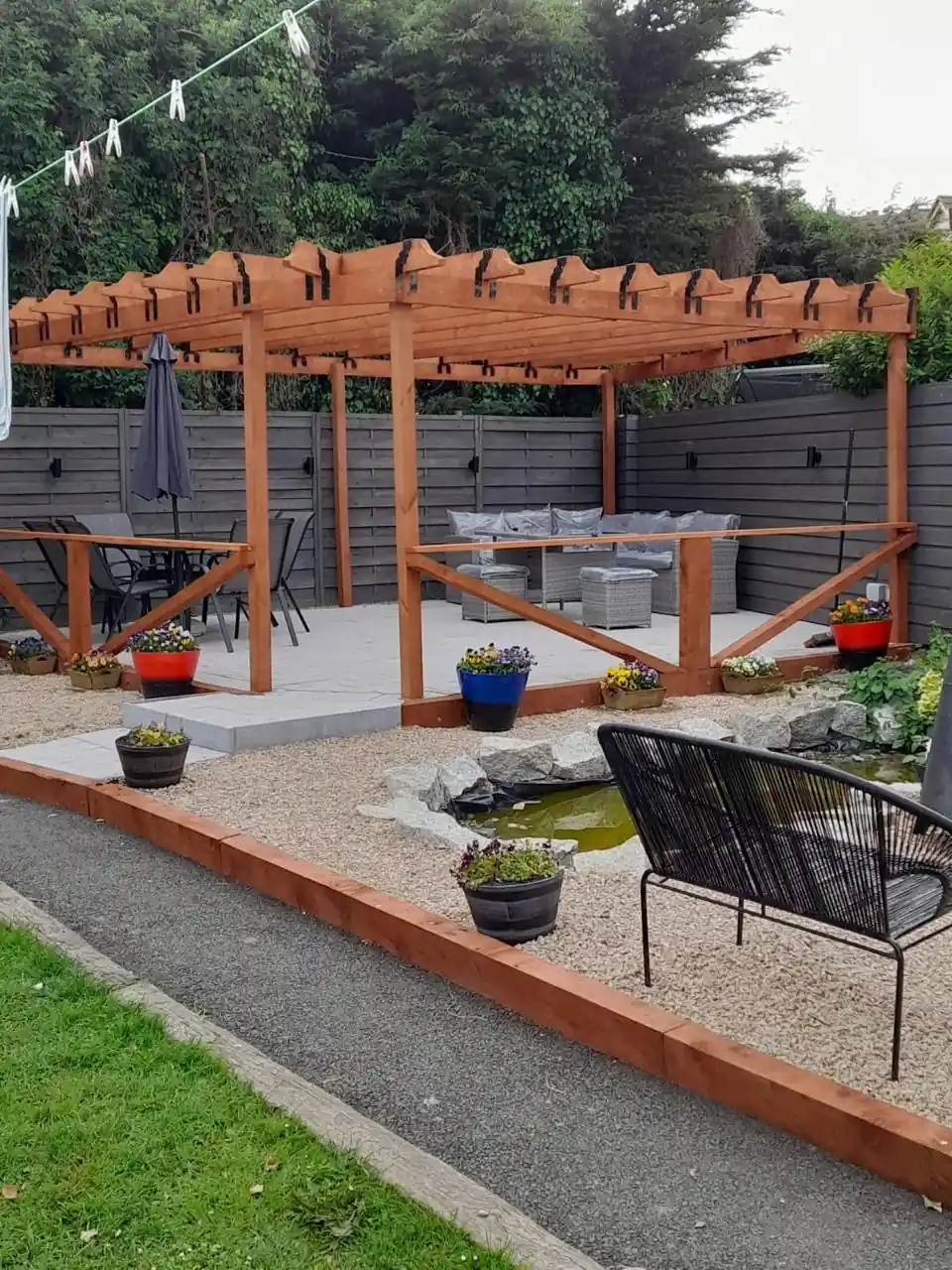Stained wooden pergola with timber balustrade in a garden
