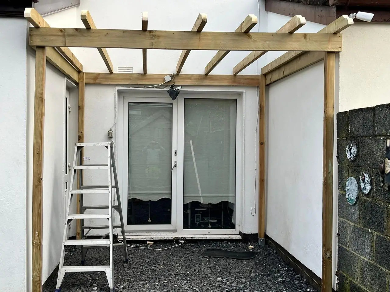 Wooden lean-to pergola positioned over patio doors